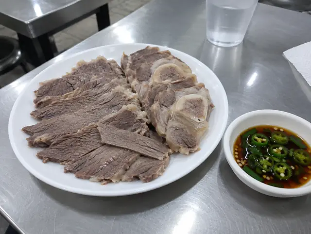 흰 접시에 담긴 수육과 고추 간장